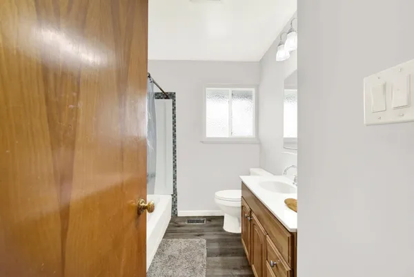 a bathroom with a sink a toilet and shower