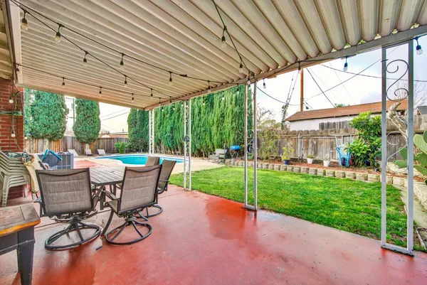 a view of a patio with a table chairs and a backyard