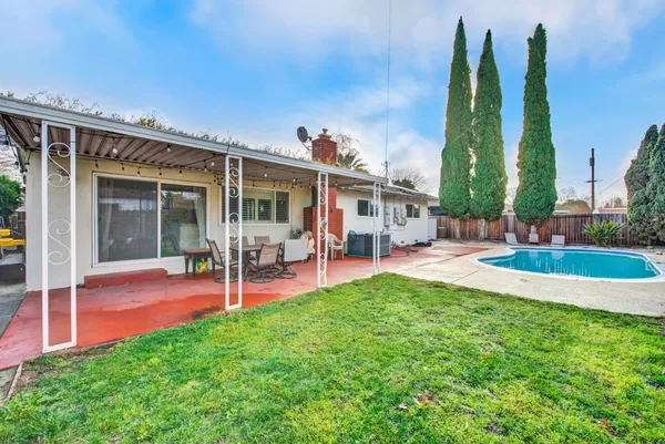 a view of a house with a yard patio and swimming pool