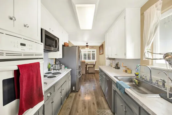 a kitchen with stainless steel appliances sink stove microwave and cabinets