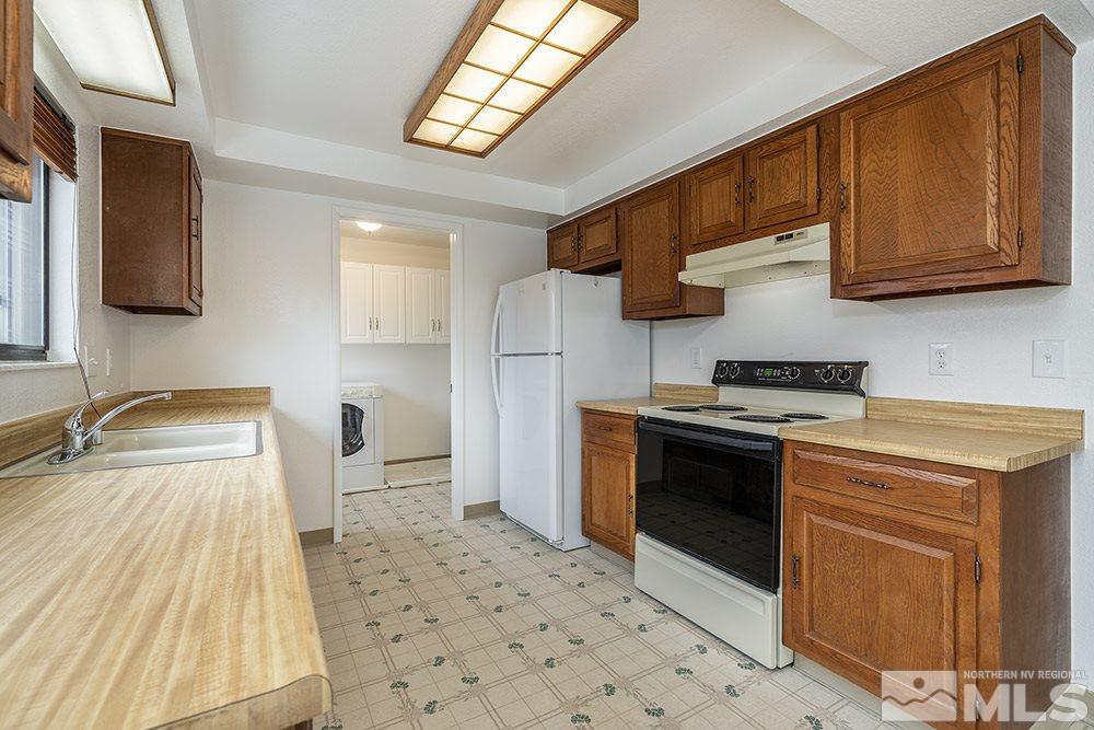 2235 Trentham Way Reno, NV 89509 - Photo 7 of 13 a kitchen with stainless steel appliances granite countertop a sink stove and refrigerator