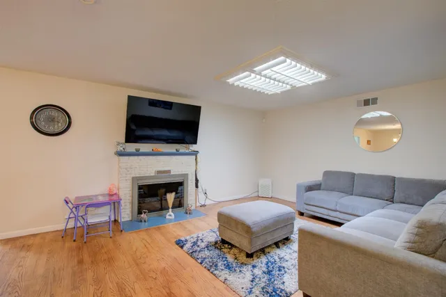a living room with furniture a fireplace and a flat screen tv