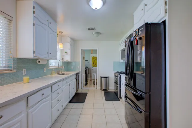 a kitchen with granite countertop white cabinets and a window