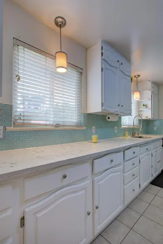 a kitchen with granite countertop white cabinets and stainless steel appliances