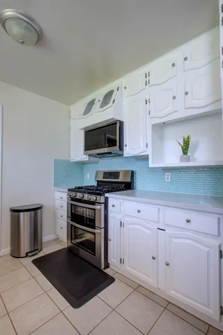 a large kitchen with stainless steel appliances granite countertop a sink stove and refrigerator