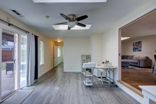a dining room with furniture potted plants and wooden floor