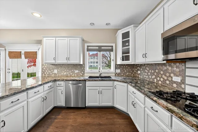 a view of an empty room with wooden floor fireplace and a window