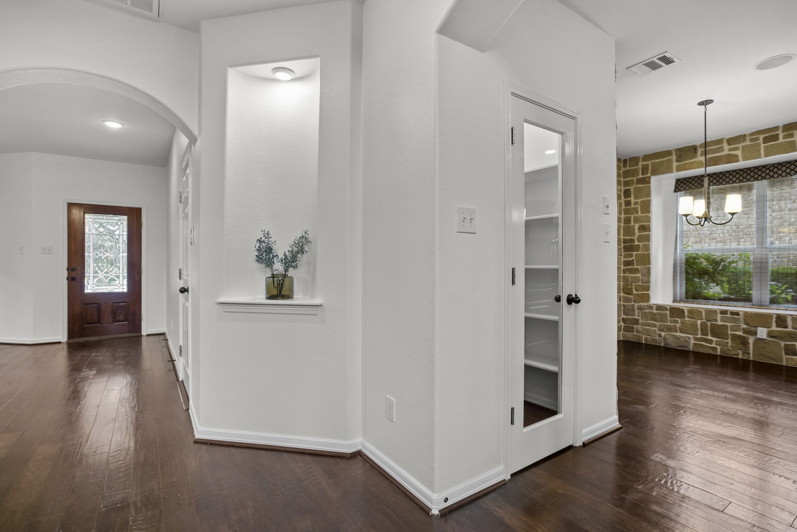 245 Razzmatazz Trail Buda, TX 78610 - Photo 7 of 37 Entryway featuring wood-finish flooring, an arched doorway, and a decorative wall niche with integrated lighting