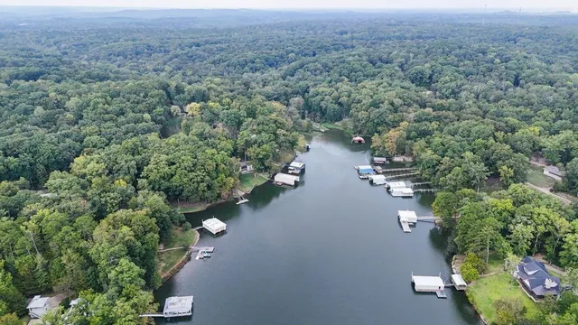 an aerial view of a house with a yard and lake view