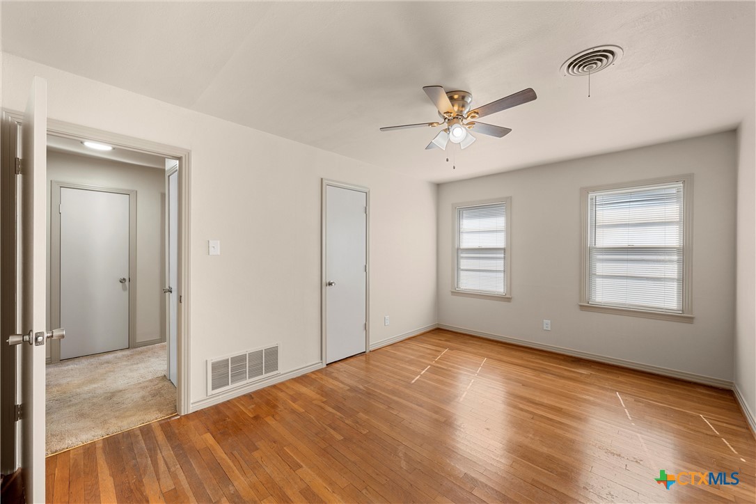 1612 South 49th Street Temple, TX 76504 - Photo 12 of 24 a view of empty room with wooden floor and fan