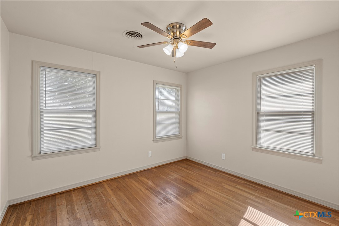 1612 South 49th Street Temple, TX 76504 - Photo 17 of 24 a view of an empty room with wooden floor and a window