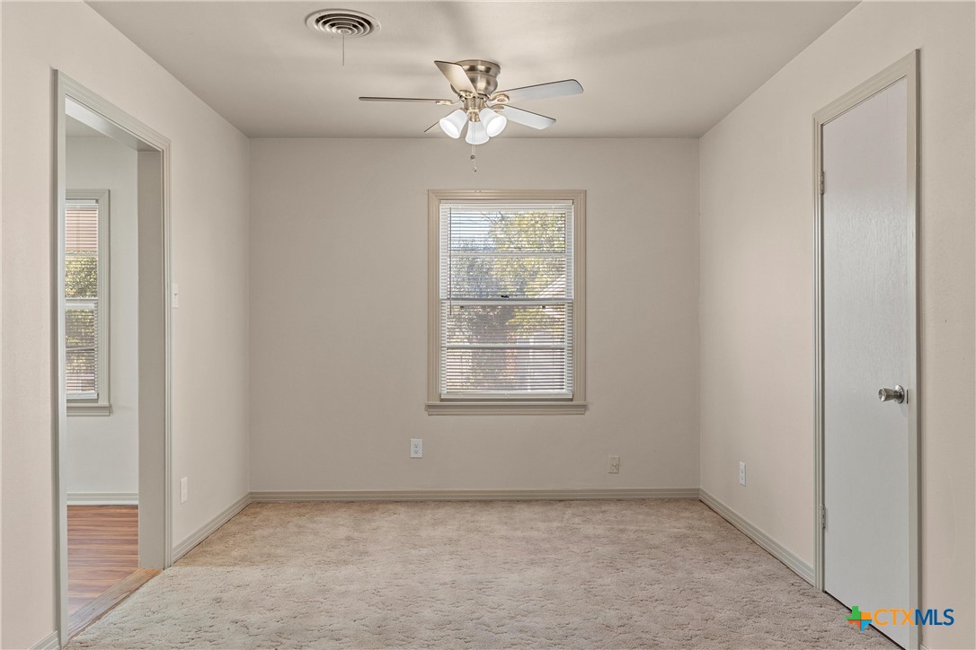 1612 South 49th Street Temple, TX 76504 - Photo 7 of 24 an empty room with chandelier fan and windows