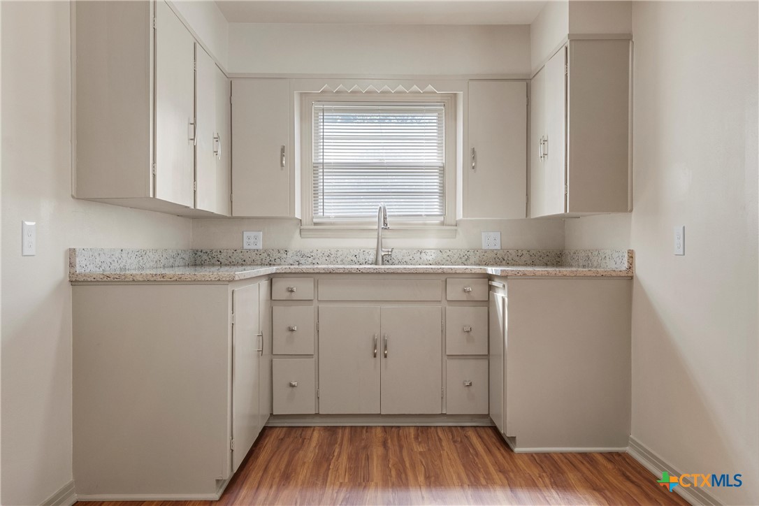 1612 South 49th Street Temple, TX 76504 - Photo 8 of 24 a kitchen with a sink window and cabinets
