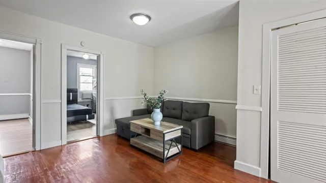 a living room with furniture and hard wood flooring