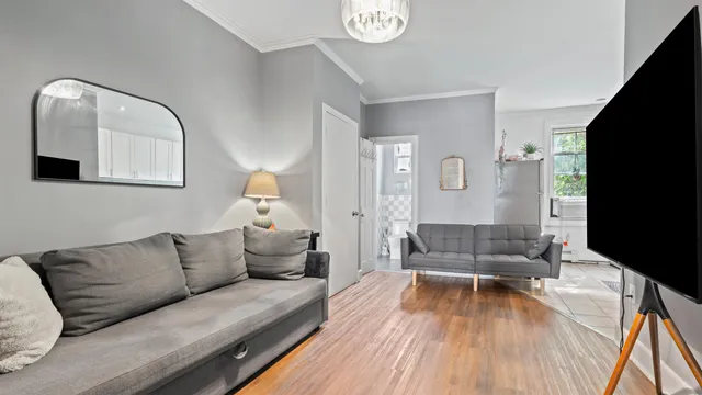 a living room with furniture a flat screen tv and a window