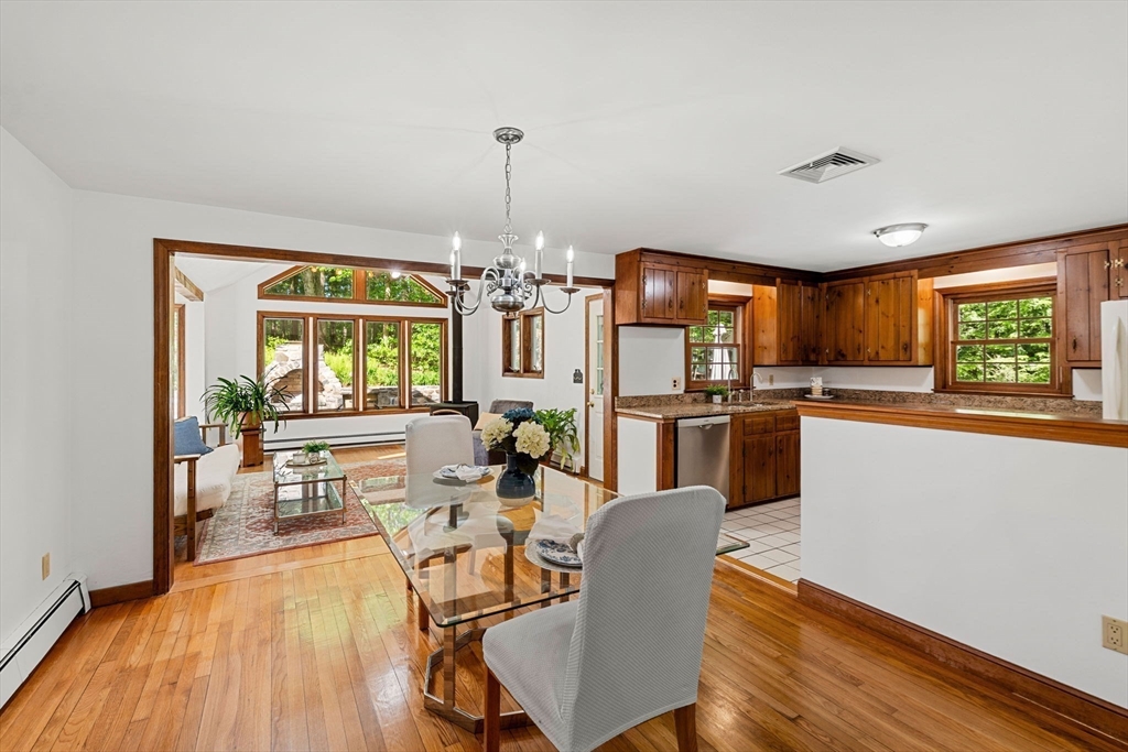 371 Longley Road Groton, MA 01450 - Photo 8 of 33 a view of a dining room and livingroom with furniture wooden floor a chandelier