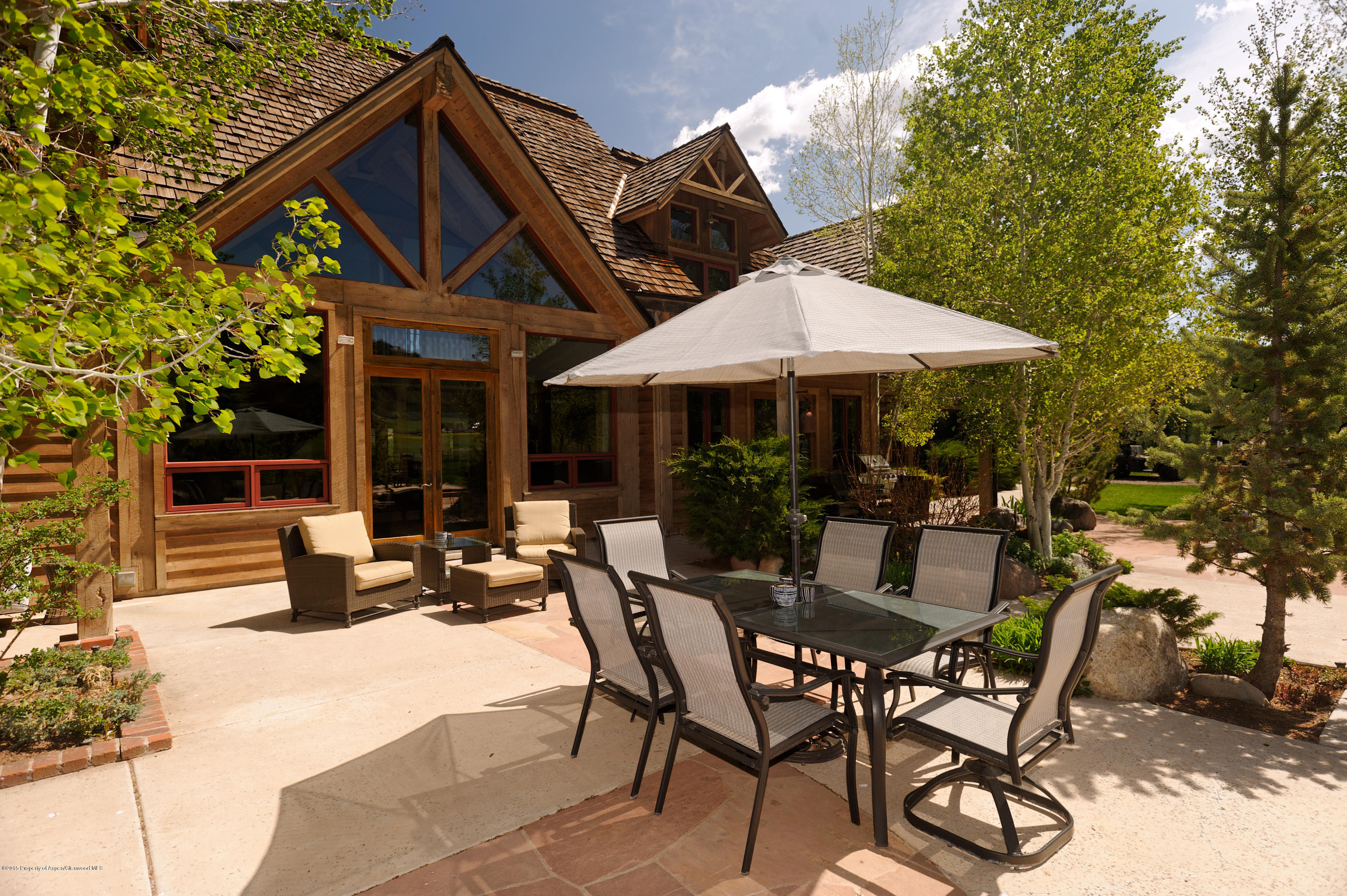 298 Red Rock Road Basalt, CO 81621 - Photo 6 of 30 a view of a patio with table and chairs under an umbrella with a barbeque