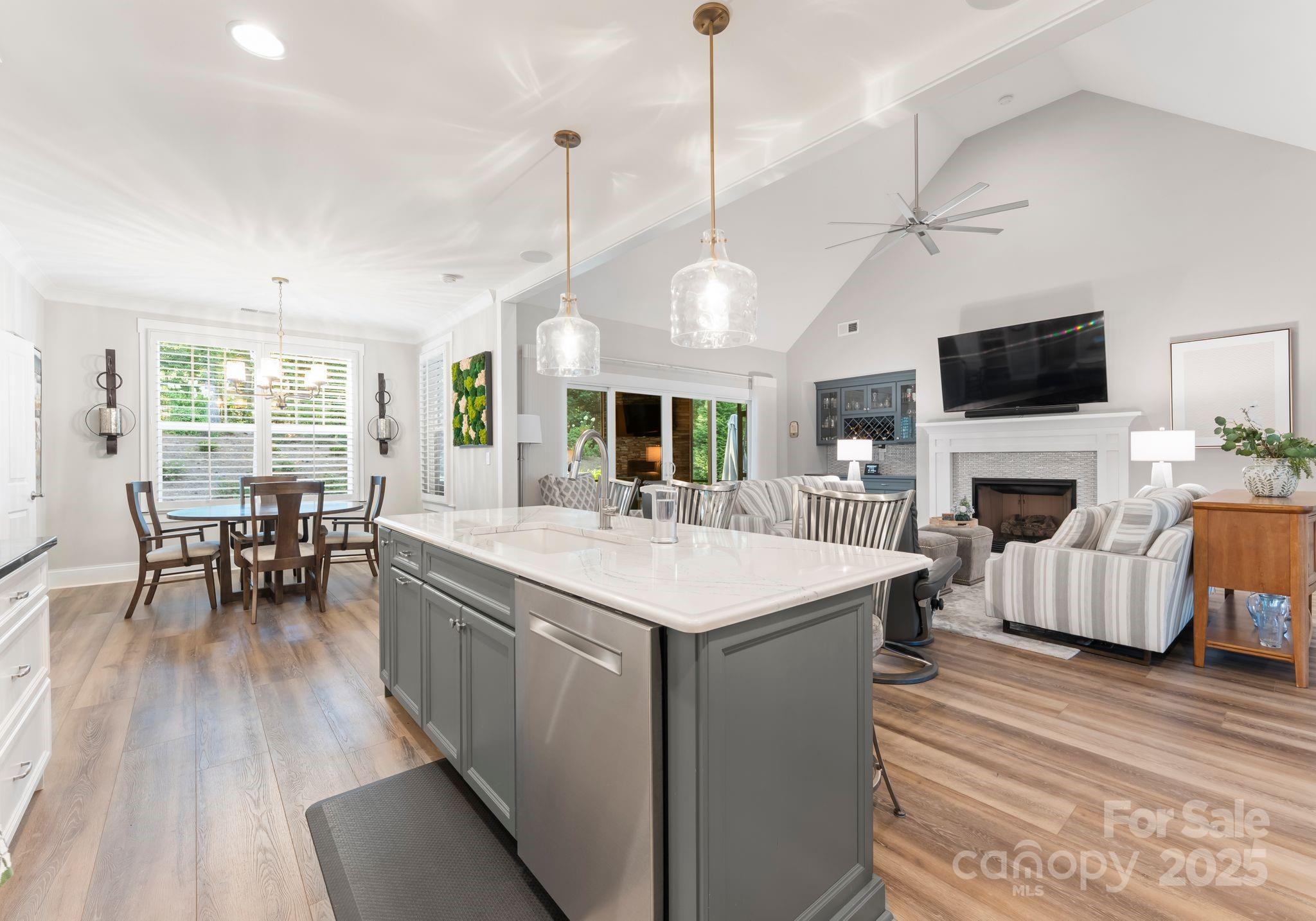 4275 Silver Eagle Cove Denver, NC 28037 - Photo 14 of 48 a large living room with a flat screen tv a rug a fireplace and a ceiling fan