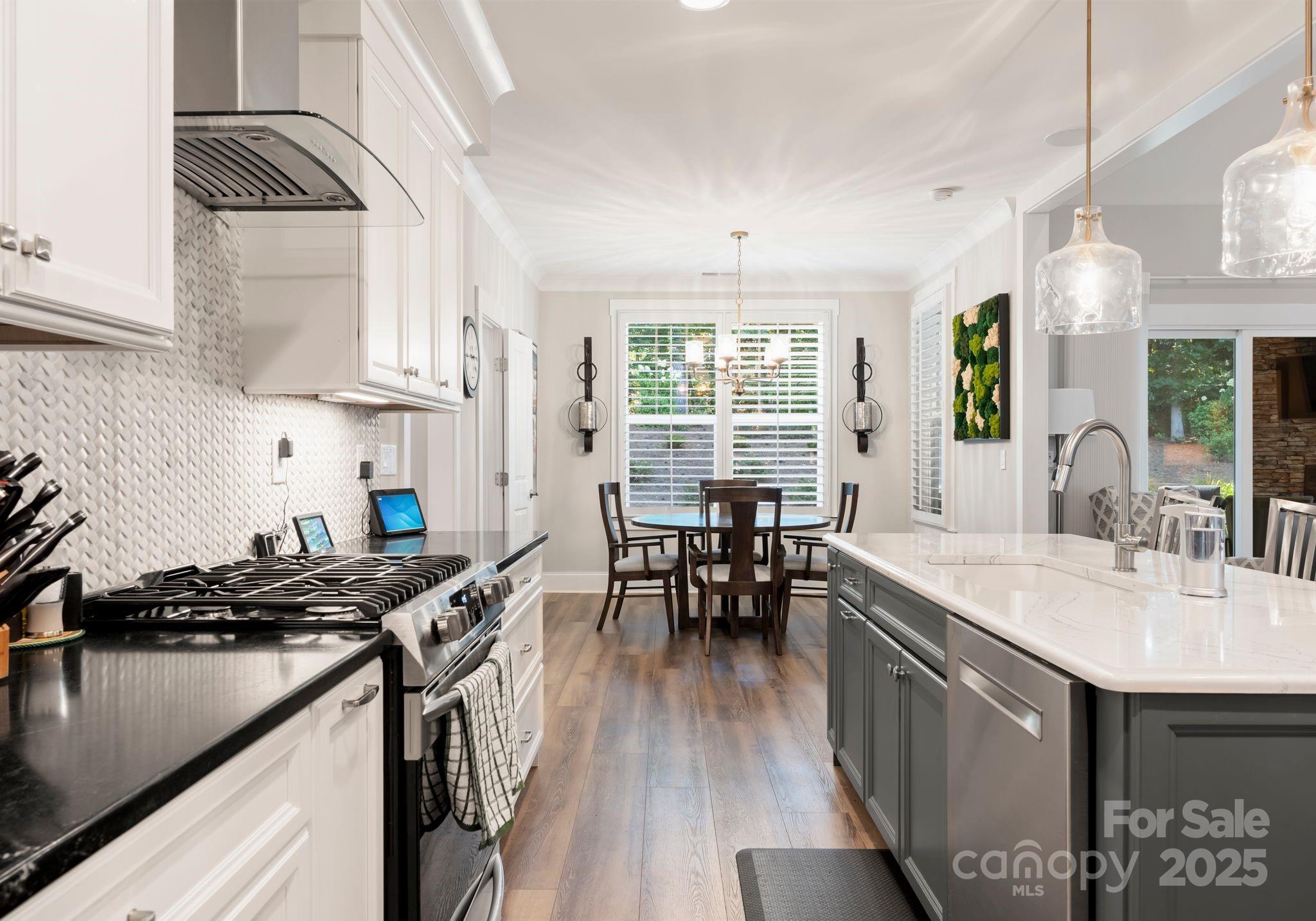 4275 Silver Eagle Cove Denver, NC 28037 - Photo 15 of 48 a kitchen with stainless steel appliances granite countertop a stove a sink dishwasher a microwave oven and a dining table with wooden floor