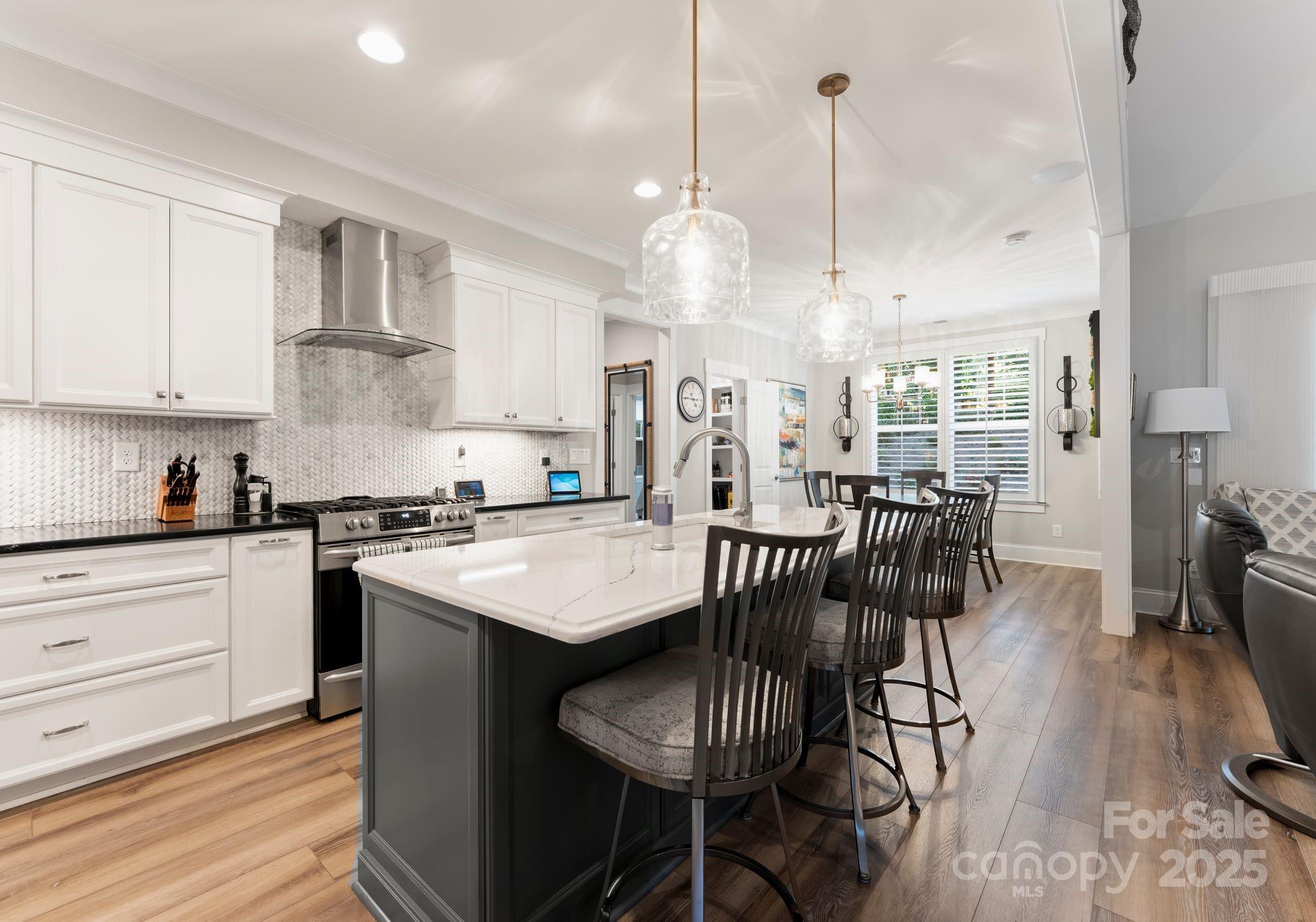 4275 Silver Eagle Cove Denver, NC 28037 - Photo 16 of 48 a kitchen with granite countertop a table chairs stove and white cabinets