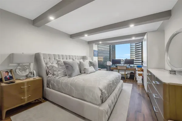 a spacious bedroom with a bed and a flat screen tv