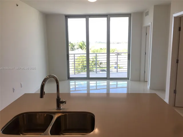 a kitchen with a sink a large window and white cabinets