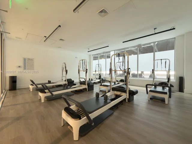 an empty room with hard wood floors and windows