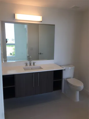 a bathroom with a sink vanity and a toilet