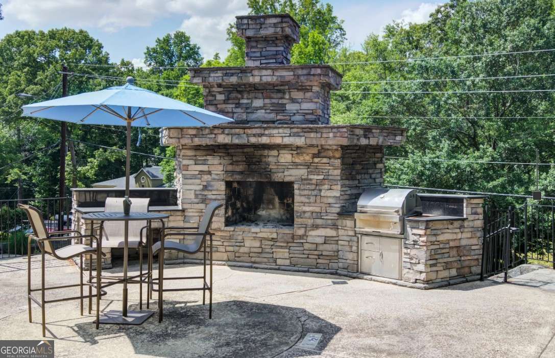 2383 Akers Mill Road Southeast, Unit L01 Atlanta, GA 30339 - Photo 13 of 30 a view of a patio with table and chairs under an umbrella