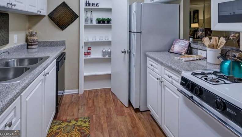 2383 Akers Mill Road Southeast, Unit L01 Atlanta, GA 30339 - Photo 25 of 30 a kitchen with stainless steel appliances granite countertop a sink stove and refrigerator