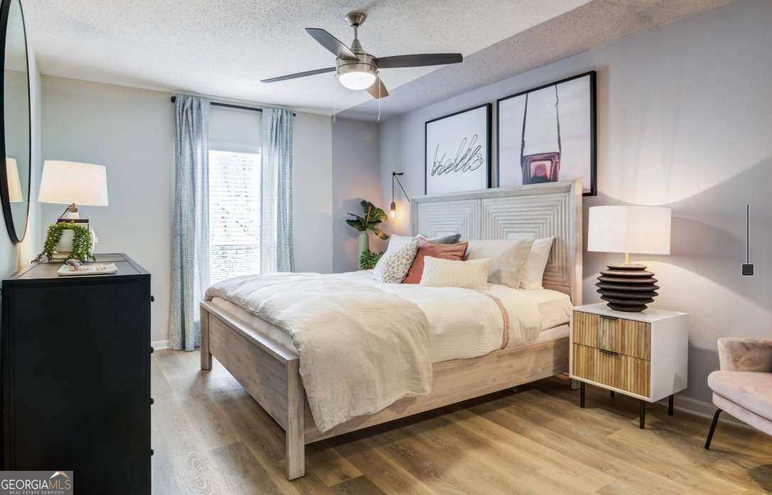 2383 Akers Mill Road Southeast, Unit L01 Atlanta, GA 30339 - Photo 7 of 30 a bedroom with a bed and wooden floor