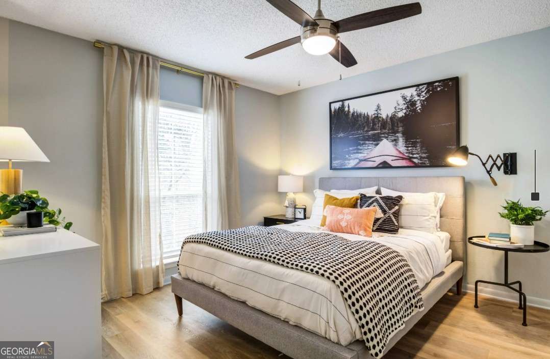 2383 Akers Mill Road Southeast, Unit L01 Atlanta, GA 30339 - Photo 8 of 30 a bedroom with a large bed and a chandelier