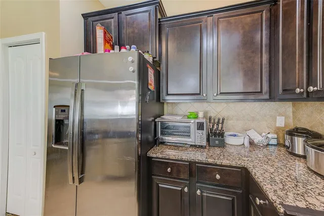 a kitchen with granite countertop a sink stove and microwave