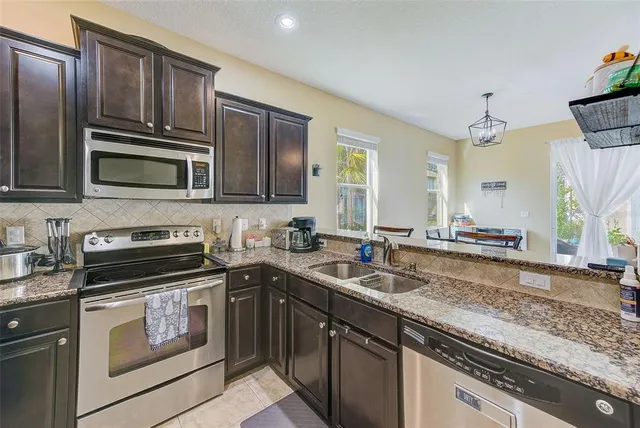 a kitchen with granite countertop a sink and a stove