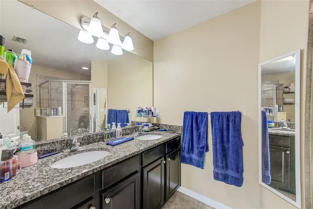 a bathroom with a granite countertop sink toilet and a mirror