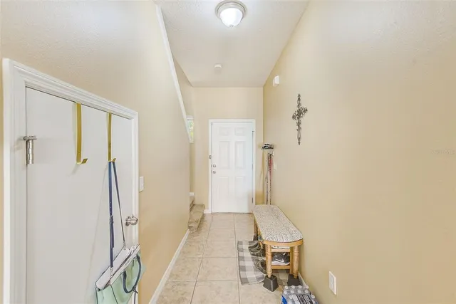 a view of a hallway with a livingroom and a bathroom with a sink