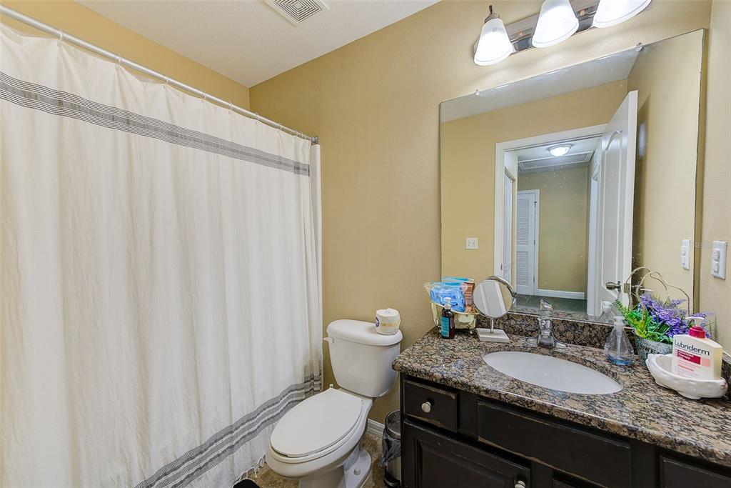 780 Spring Flowers Trail Brandon, FL 33511 - Photo 24 of 33 a bathroom with a granite countertop sink toilet and a mirror