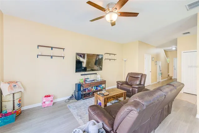 a living room with furniture a flat screen tv and a large window