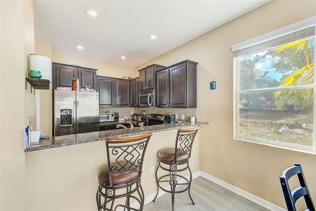a kitchen with stainless steel appliances granite countertop a refrigerator stove and sink