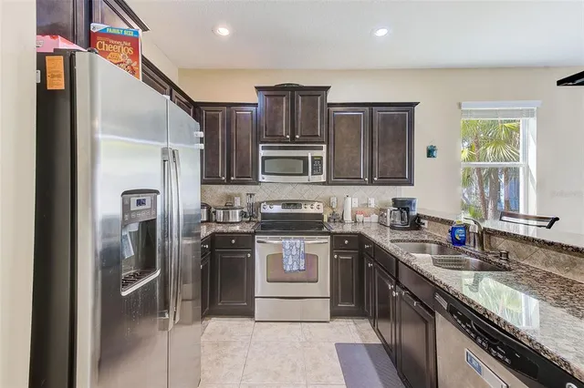 a kitchen with granite countertop stainless steel appliances and wooden cabinets