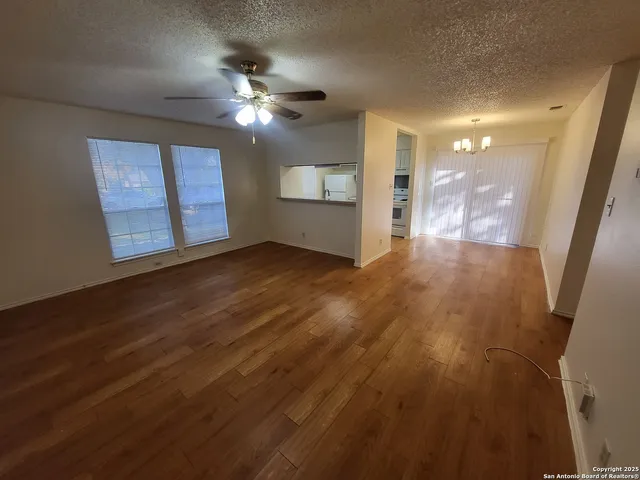a view of a livingroom with a ceiling fan window and hardwood floor
