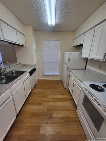 a kitchen with sink stove and cabinets