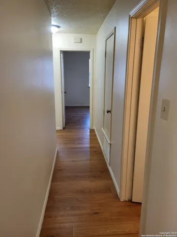a view of a hallway with wooden floor