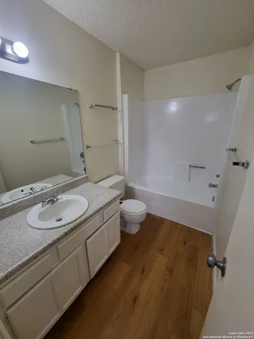 a bathroom with a granite countertop sink a toilet and a mirror