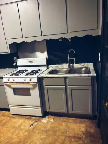 a white stove top oven sitting inside of a kitchen