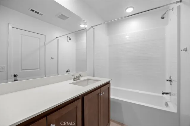 a bathroom with a sink double vanity mirror and a bathtub
