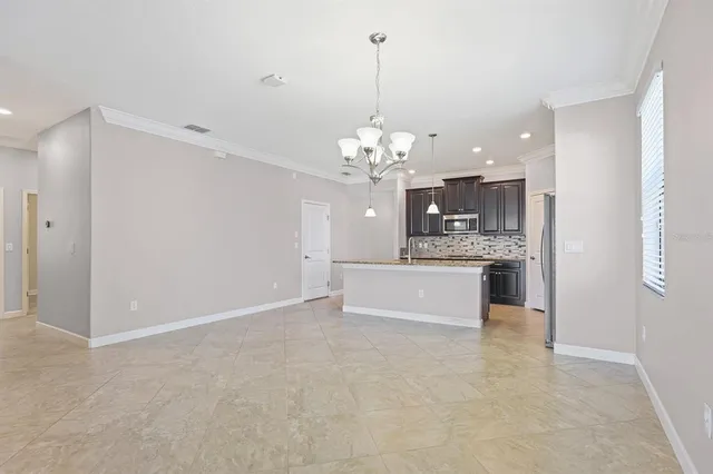 a large kitchen with a sink and chandelier