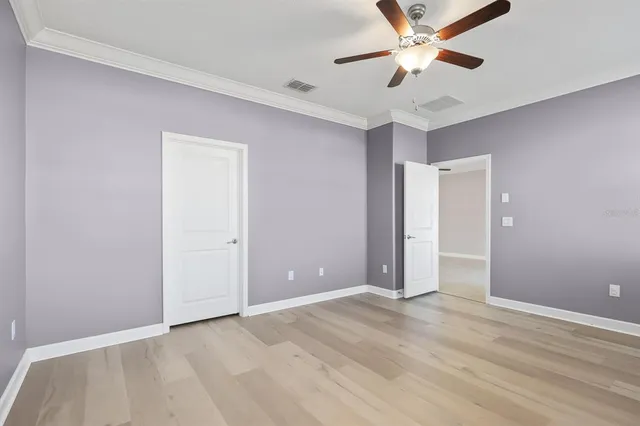 a view of an empty room and window a ceiling fan