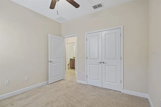 an empty room with chandelier fan