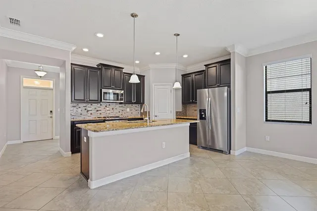 a large kitchen with kitchen island granite countertop a large counter top stainless steel appliances and cabinets
